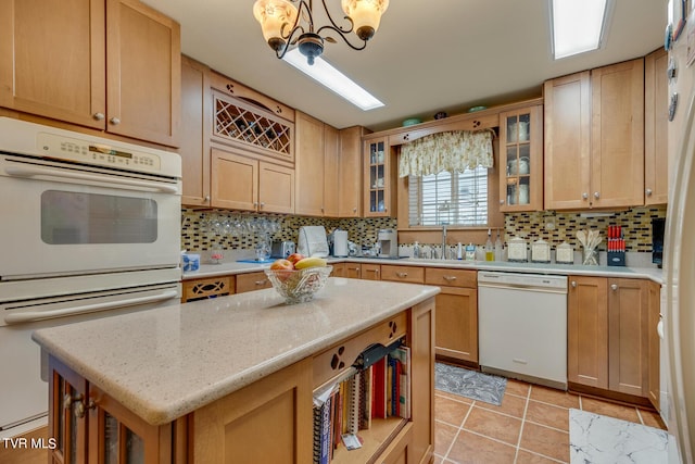 kitchen featuring tasteful backsplash, a center island, white dishwasher, and light tile patterned floors