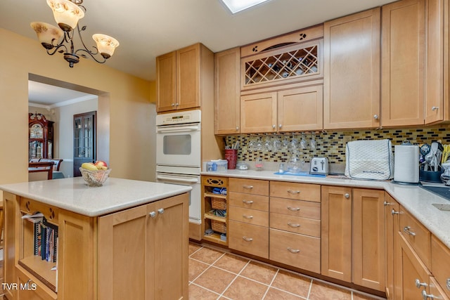 kitchen with double oven, backsplash, light countertops, and crown molding