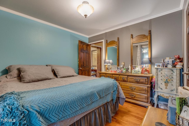 bedroom with ornamental molding and light wood-style floors