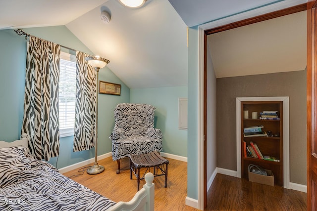 sitting room with baseboards, vaulted ceiling, and wood finished floors