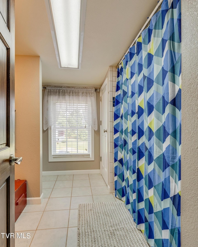 full bathroom featuring tile patterned flooring, baseboards, and a shower with curtain