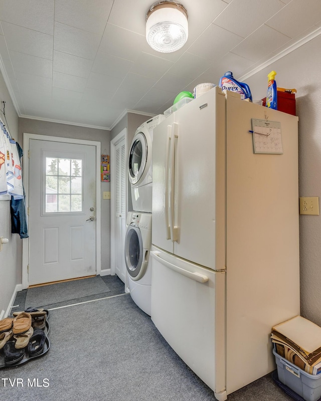 laundry area featuring ornamental molding, carpet, stacked washer and clothes dryer, and laundry area