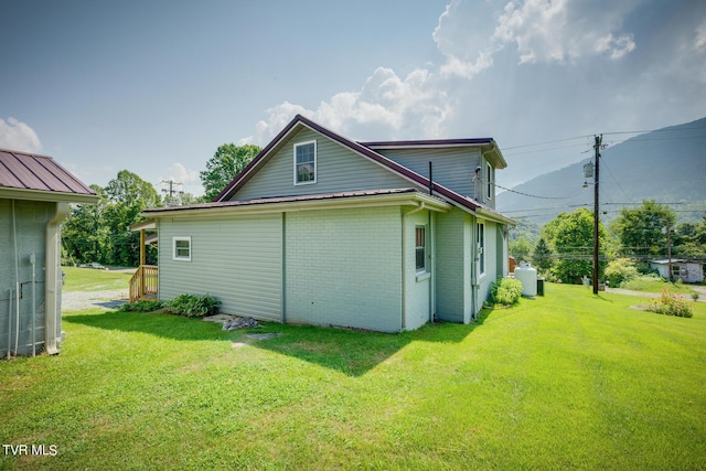 rear view of property with a yard and brick siding