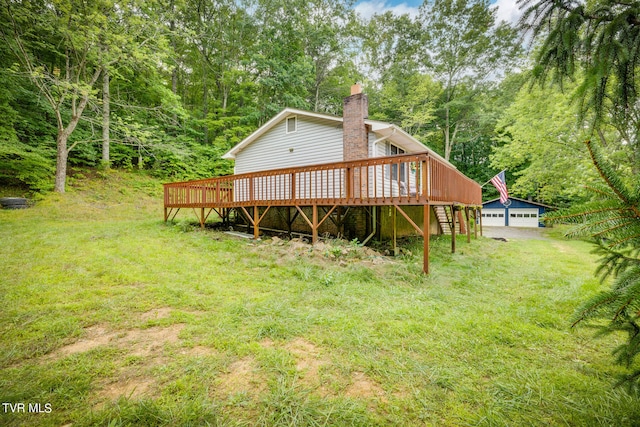 back of house featuring a yard, an outbuilding, a wooden deck, and a garage