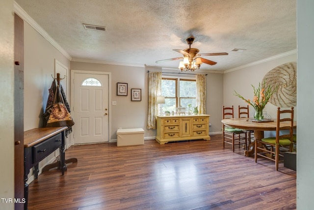 entrance foyer with a textured ceiling, dark hardwood / wood-style flooring, and ornamental molding