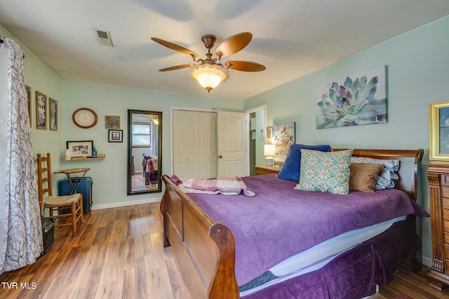 bedroom with dark hardwood / wood-style floors, a closet, and ceiling fan