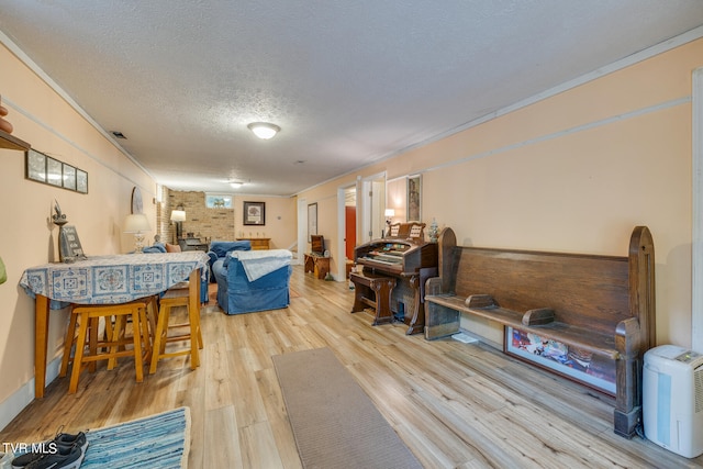 interior space with light hardwood / wood-style flooring, a textured ceiling, and brick wall