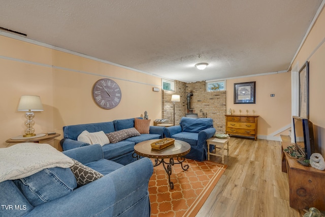 living room featuring a wood stove, brick wall, hardwood / wood-style floors, ornamental molding, and a textured ceiling