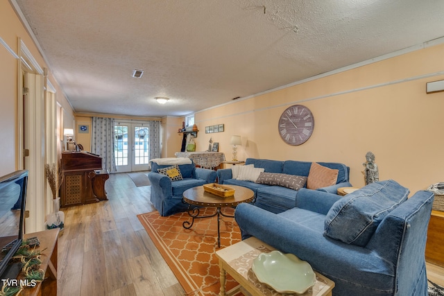 living room with french doors, a textured ceiling, and wood-type flooring