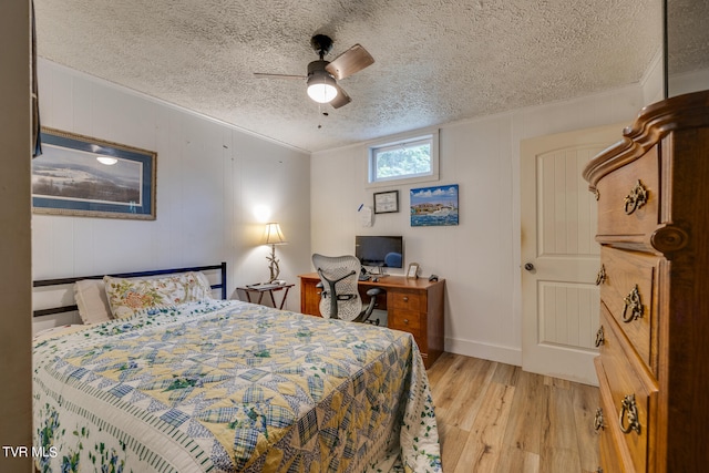 bedroom featuring ornamental molding, a textured ceiling, light hardwood / wood-style floors, and ceiling fan