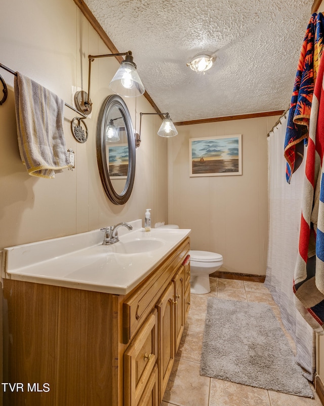 bathroom with a textured ceiling, toilet, vanity, crown molding, and tile patterned flooring