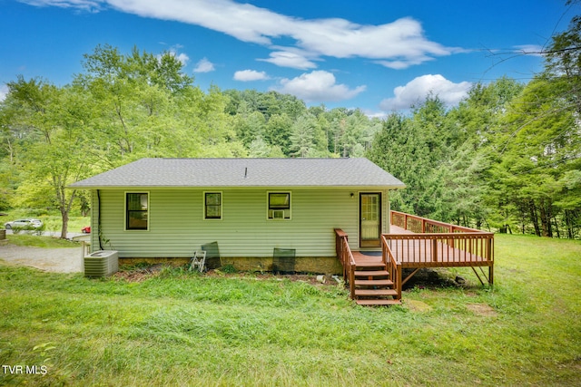 rear view of property with a yard, a deck, and central air condition unit