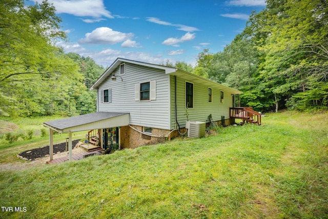 view of property exterior with a wooden deck, central AC unit, and a lawn