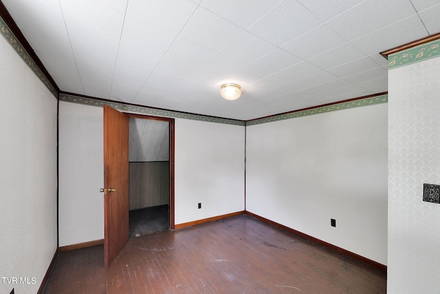 unfurnished room featuring ornamental molding and dark hardwood / wood-style floors