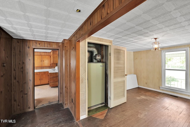 interior space featuring wooden walls, dark hardwood / wood-style floors, and a notable chandelier