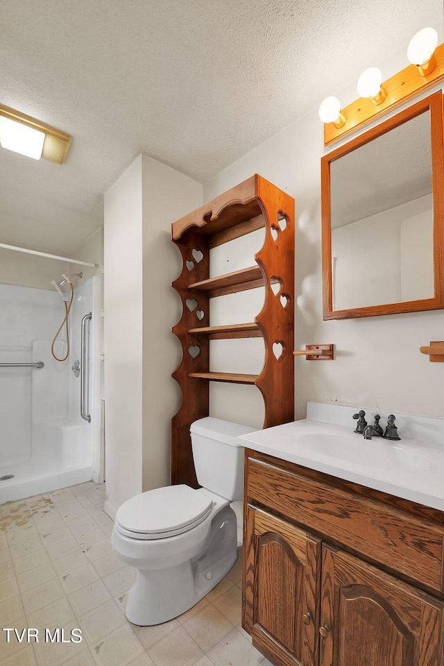 bathroom with vanity, toilet, a textured ceiling, and walk in shower