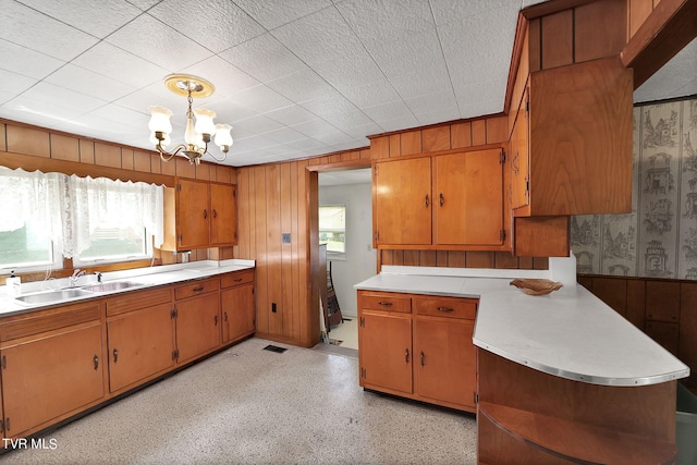 kitchen featuring pendant lighting, sink, and a chandelier