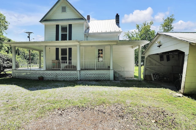 rear view of property with covered porch and a lawn