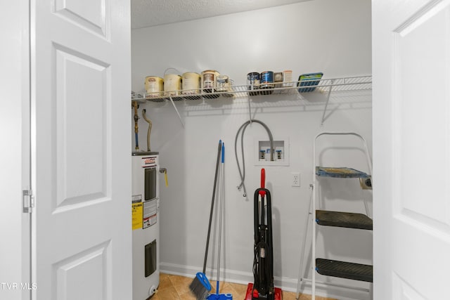 laundry area featuring water heater, a textured ceiling, and washer hookup