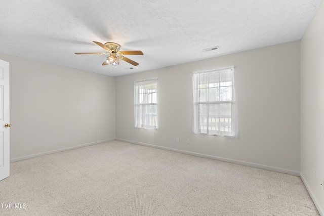 carpeted empty room with ceiling fan and a textured ceiling