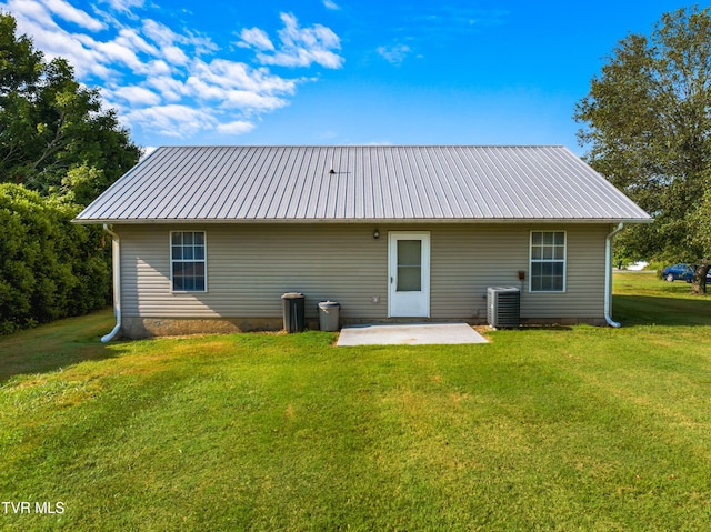 rear view of property featuring a lawn, a patio, and cooling unit