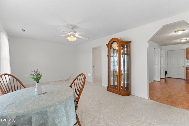 dining room with ceiling fan and light carpet