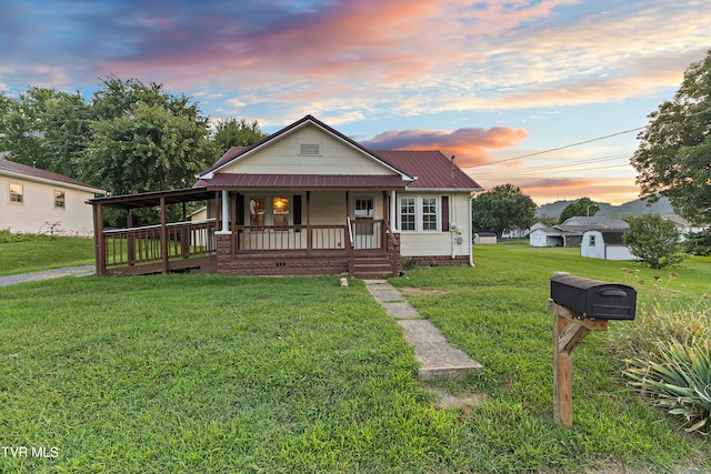 view of front of house with an outdoor structure, covered porch, and a yard