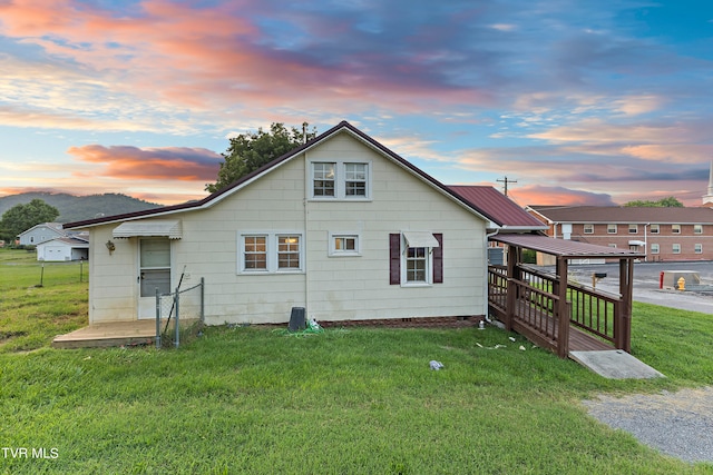 back house at dusk with a lawn