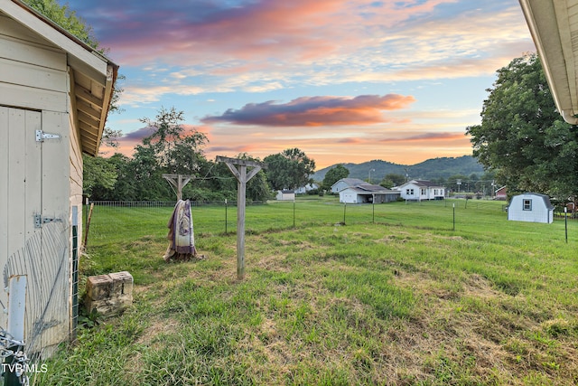 yard at dusk featuring a storage shed