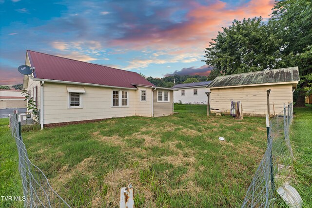 back house at dusk with a yard