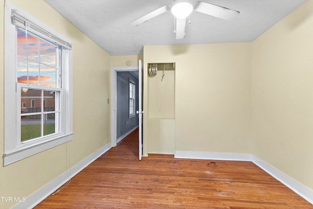 empty room with ceiling fan and hardwood / wood-style floors