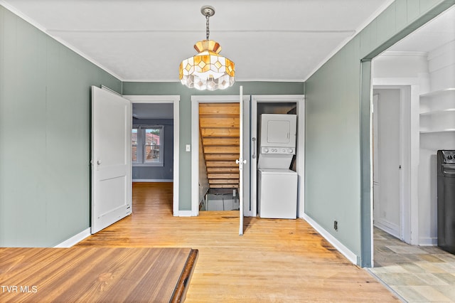 unfurnished bedroom with stacked washer and dryer and light hardwood / wood-style floors