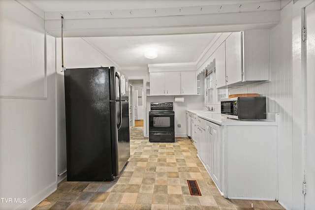 kitchen featuring black refrigerator, range, light tile patterned flooring, white cabinetry, and sink