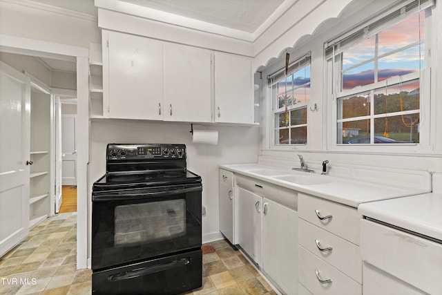 kitchen featuring white cabinetry, crown molding, light tile patterned floors, sink, and black / electric stove