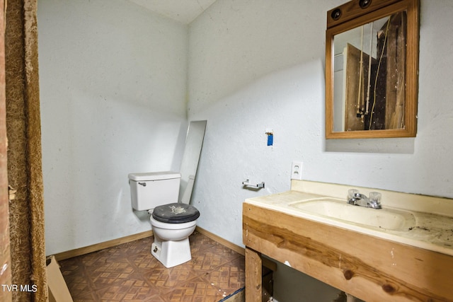 bathroom featuring vanity, parquet flooring, and toilet