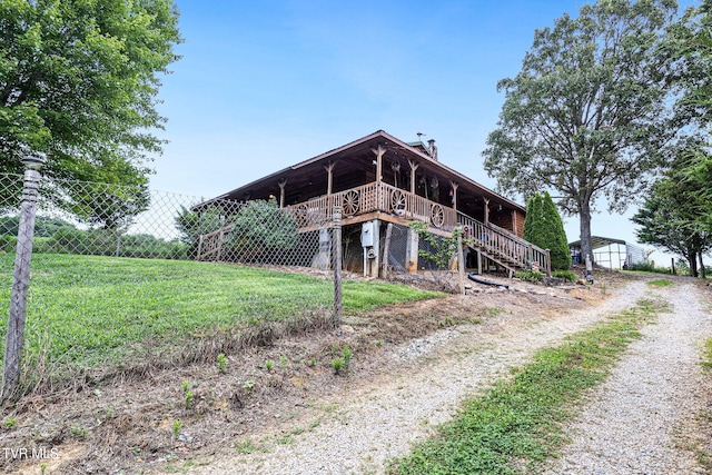 back of house featuring a deck and a yard