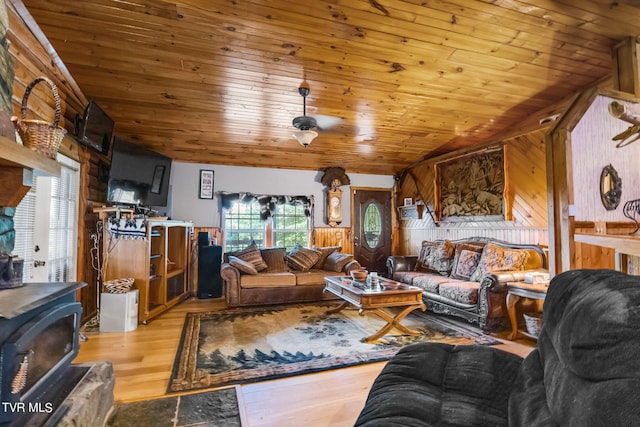 living room featuring lofted ceiling, wooden walls, and light hardwood / wood-style floors