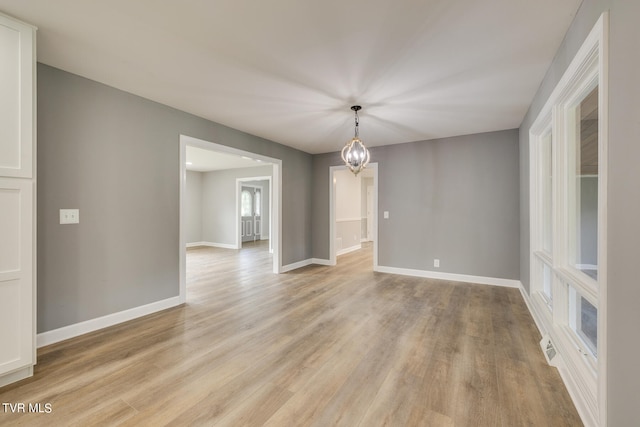 interior space with a notable chandelier and light wood-type flooring