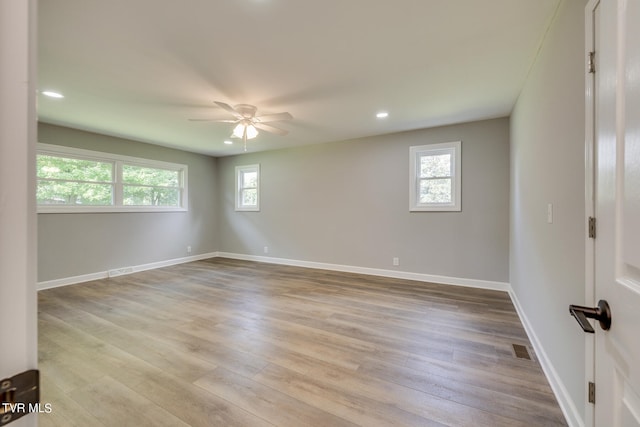 unfurnished room with light wood-type flooring, plenty of natural light, and ceiling fan