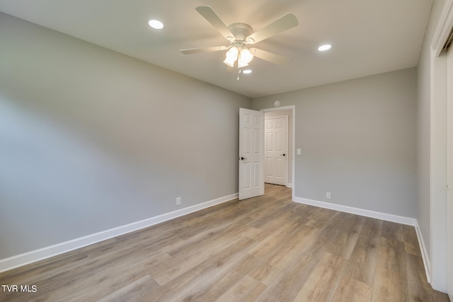 empty room with ceiling fan and light hardwood / wood-style flooring