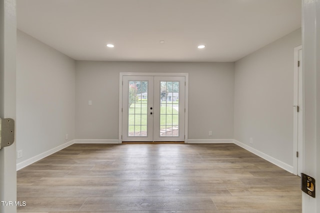 empty room with light wood-type flooring and french doors