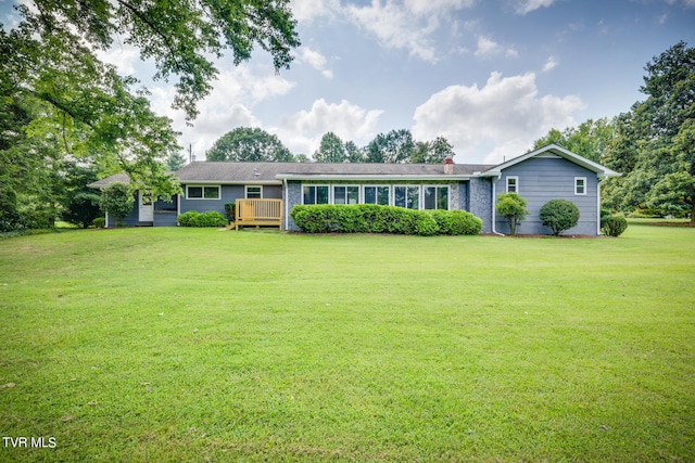 single story home featuring a wooden deck and a front yard