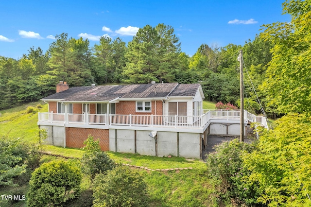 rear view of house with a wooden deck and a yard