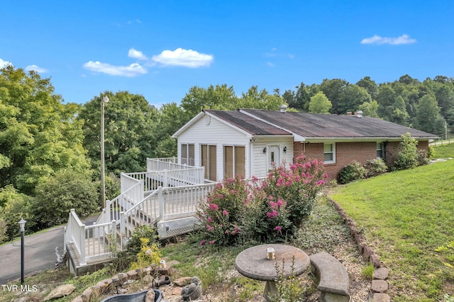 view of front of house featuring a front lawn and a wooden deck