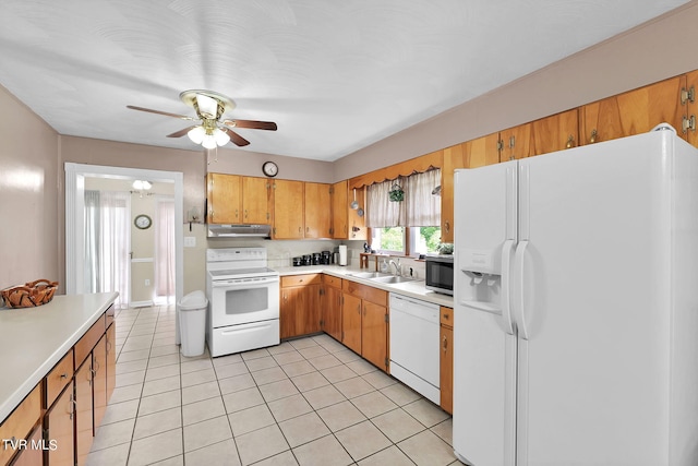 kitchen with white appliances, light tile patterned floors, sink, and ceiling fan