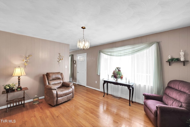 living area featuring an inviting chandelier and light hardwood / wood-style floors