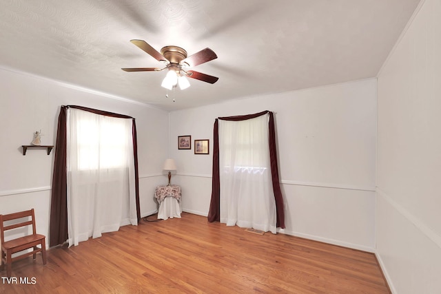 unfurnished room with a textured ceiling, light hardwood / wood-style flooring, and ceiling fan