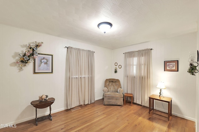 sitting room with a textured ceiling and light hardwood / wood-style flooring