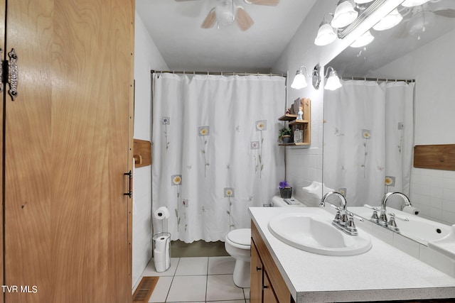 bathroom with a shower with shower curtain, tile patterned flooring, toilet, ceiling fan, and vanity