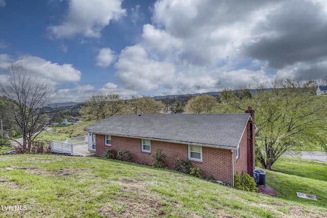 172 Lee Ave, Lebanon, VA 24266 - back of property with a chimney, a yard, a shingled roof, and brick siding